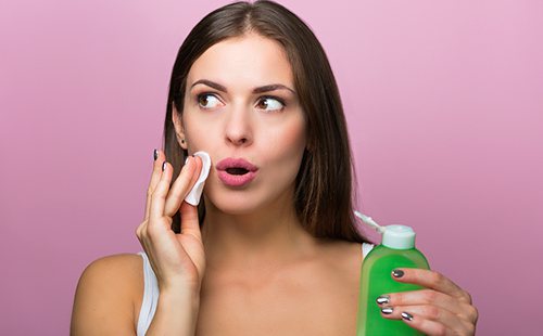 Хорошенькая девушка протирает лицо тоником